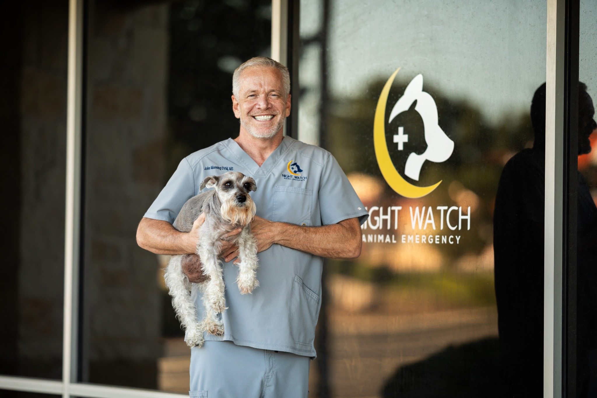Dr. John Manning holding his dog Buff outside Night Watch Animal Emergency
